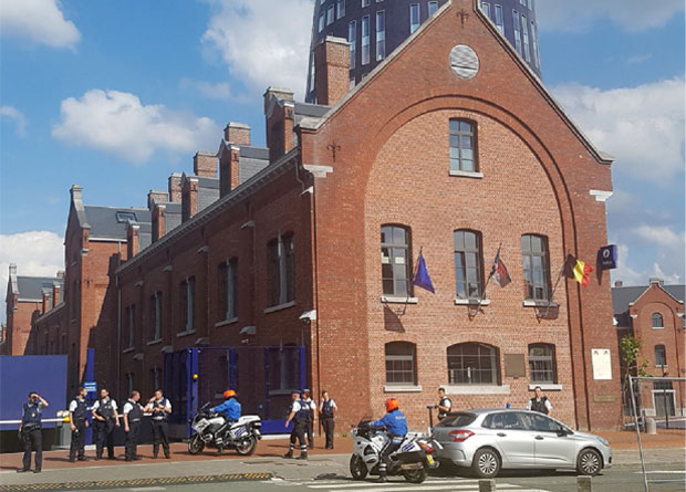A photo taken with a mobile phone on August 6, 2016, shows police securing the area around a police building in the southern Belgian city of Charleroi following a machete attack. Two policewomen were wounded in Charleroi by a machete-wielding man who shouted "Allahu akbar" (God is the greatest), local police said. The attacker was shot and injured, they said on Twitter. / AFP PHOTO / BELGA AND Belga / FRED DUBOIS / Belgium OUT