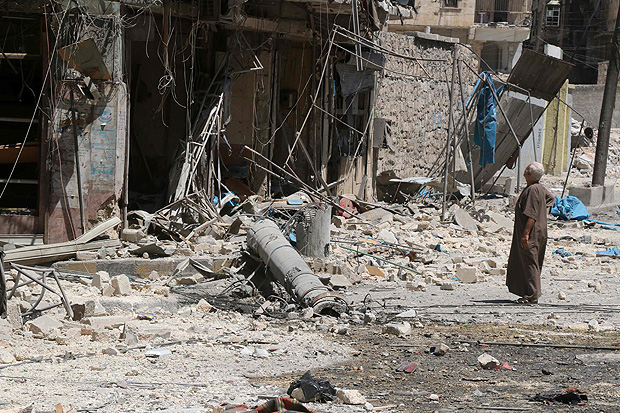 Morador de Aleppo, no norte da Sria, observa destruio causada por bombardeios areos nesta tera-feira (16)