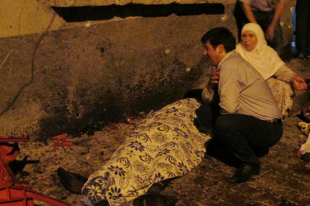 Pessoas ao lado de uma das vtimas do ataque a um casamento em Gaziantep, na Turquia