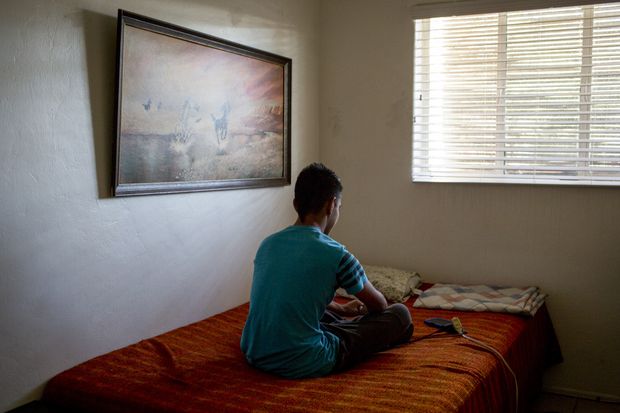 A 15-year-old boy from El Salvador in his uncle's home in Tucson, Ariz., Aug. 15, 2016. He is asking for asylum in Arizona after fleeing gang violence back home, but he did not have a lawyer in immigration court. Since October 2004, more than half of children who did not have lawyers were deported, while only one in 10 children who had lawyers were sent back. (Caitlin O'Hara/The New York Times) - XNYT50