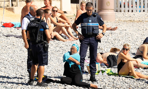 Polciais confrontam uma mulher em Nice nesta tera-feira e falam sobre a proibio de burquni nas praias francesas