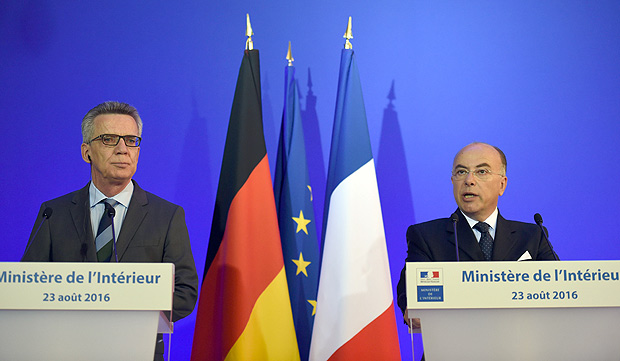 Os ministros do Interior da Alemanha, Thomas de Maizire ( esq.) e da Frana, Bernard Cazeneuve