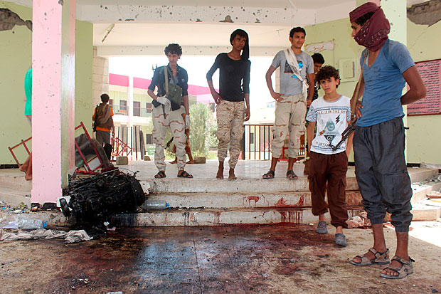 Iemenitas observam ptio coberto de sangue em local alvo de ataque do Estado Islmico em Aden