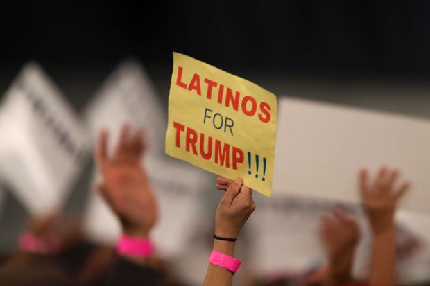 Mulher segura cartaz defendendo apoio dos eleitores latinos ao republicano Donald Trump