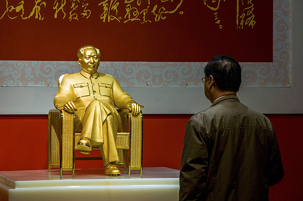 A visitor stands in front of a statue of China's late Chairman Mao Zedong made of gold, jadeite and diamond during an exhibition in Shenzhen, Guangdong province, December 13, 2013. According to local media, the 50 kg (110 lbs) statue is worth more 100,000,000 yuan ($16,470,000). REUTERS/Stringer (CHINA - Tags: POLITICS SOCIETY) CHINA OUT. NO COMMERCIAL OR EDITORIAL SALES IN CHINA ORG XMIT: PEK20