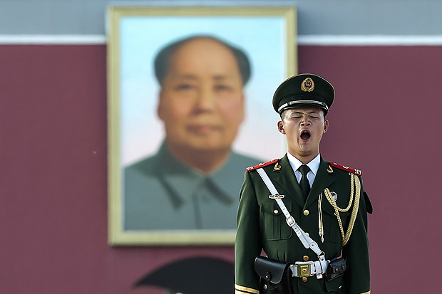 This photo taken on July 13, 2016 shows a paramilitary policeman standing guard in Beijing's Tiananmen Square, near the portrait of late communist leader Mao Zedong. The Philippines urged Beijing on July 14 to respect an international tribunal's ruling that rejected Chinese claims to most of the South China Sea, and said it would raise the issue at a regional summit. / AFP PHOTO / STR ORG XMIT: GB6243