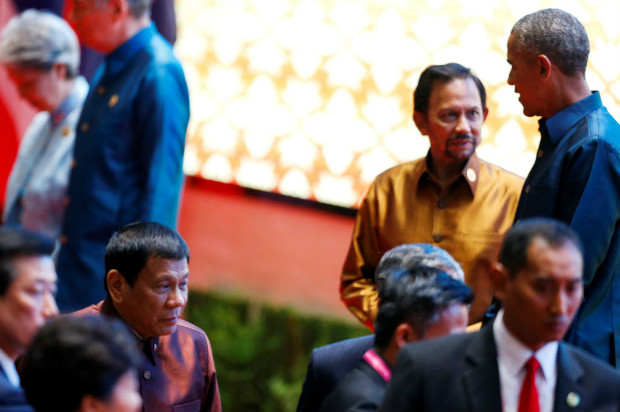 Obama conversa com o sulto do Brunei, Hassanal Bolkiah, enquanto Duterte ( dir.) passa em corredor