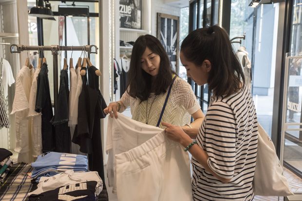 Wu Jingjing, 29, left, shops with her friend Pengpeng in Beijing, Sept. 6, 2016. Wu, who is single and works at an internet company, said young people in China no longer just want someone to marry, they want a relationship based on love. The decline in marriages in China means a decline in the number of babies, and potentially less spending, which China needs to drive economic growth. (Gilles Sabrie/The New York Times) - XNYT159
