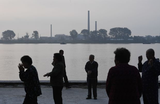 Residents exercise on the bank of the Yalu river in Dandong, in northeast China on September 12, 2016, as the North Korean town of Sinuiju is seen across the river. North Korea demanded on September 11, 2016 that the United States recognise it as a "legitimate nuclear weapons state" following its fifth and largest atomic test. / AFP PHOTO / GREG BAKER ORG XMIT: GB6461
