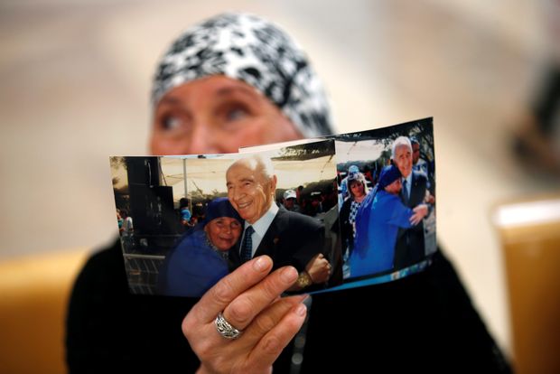A woman shows her support as she holds up a photograph of herself with former Israeli President Shimon Peres during a briefing to members of the media on the medical condition of Peres a day after he suffered a stroke, at a hospital near Tel Aviv, Israel September 14, 2016. REUTERS/Baz Ratner ORG XMIT: GGGJER09