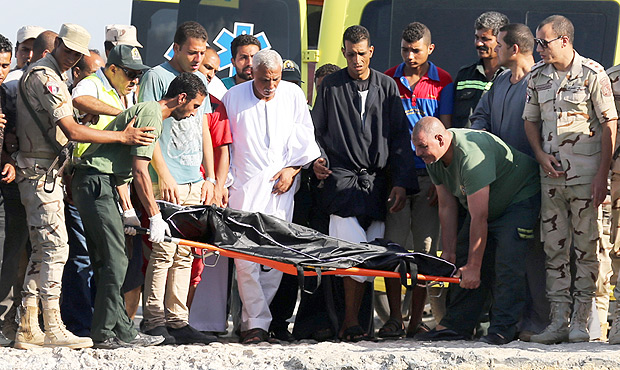 Socorristas carregam corpo de migrante que morreu em naufrgio de barco de pesca no litoral do Egito