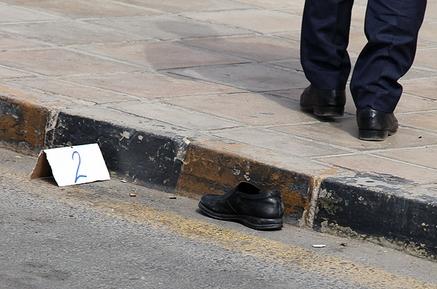 The shoe of prominent Jordanian writer Nahed Hattar is seen at the site where he was assassinated as Jordanian forensics inspect the scene outside a court in Amman where he was facing charges for sharing a cartoon deemed offensive to Islam, state news agency Petra reported on September 25, 2016. Hattar was struck by three bullets before the assailant was arrested, said Petra. Witnesses told AFP that a man had opened fire in front of the court in Amman's Abdali district. / AFP PHOTO / AHMAD ALAMEEN ORG XMIT: amm02
