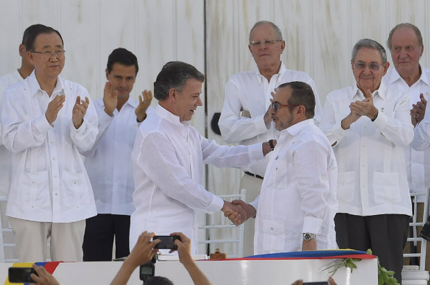 (160926) -- CARTAGENA, septiembre 26, 2016 (Xinhua) -- Imagen cedida por Presidencia de Colombia, del presidente de Colombia, Juan Manuel Santos (c-i-frente) estrechando la mano con Rodrigo Londoo Echeverri (c-d-frente), alias "Timochenko" durante la ceremonia de la firma del acuerdo por la paz, en Cartagena de Indias, Colombia, el 26 de septiembre de 2016. La firma de la paz se lleva a cabo en las afueras del Centro de Convecciones de Cartagena, donde tambin estn invitados cancilleres, ex mandatarios y dirigentes de organismos multilaterales. En ese acto estn presentes 14 mandatarios de la regin. En la ceremonia del Acuerdo Final para la Terminacin del Conflicto y la Construccin de una Paz Estable y Duradera, firmarn el presidente Juan Manuel Santos y el mximo lder de las FARC, Rodrigo Londoo Echeverri, conocido con los alias de "Timolen Jimnez" o "Timochenko". (Xinhua/Juan Pablo Bello/Presidencia de Colombia) (da) (dp)