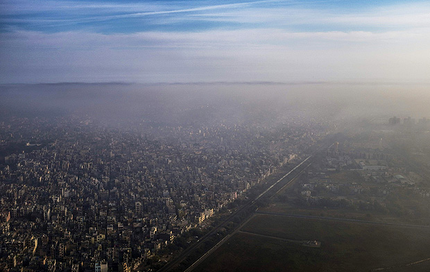 (FILES) In this photograph taken on March 15, 2016, a blanket of smog extends over a densely populated neighborhood adjacent to the main airport in New Delhi. India, the world's third biggest carbon emitter, is set to ratify the Paris agreement on climate change October 2, 2016, on the birthday of the country's famously ascetic independence leader Mahatma Gandhi. / AFP PHOTO / Roberto SCHMIDT