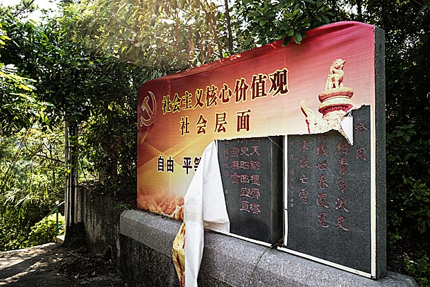 Escultura de pedra em museu da Revoluo Cultural da China coberto com uma bandeira rasgada sobre valores socialistas 