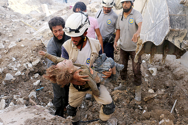 A Syrian civil defence volunteer, known as the White Helmets, holds the body of a child after he was pulled from the rubble following a government forces air strike on the rebel-held neighbourhood of Karm Homad in the northern city of Aleppo, on October 4, 2016. Syrian regime forces advanced against rebels during intense street battles in the heart of Aleppo, after the United States abandoned talks with Russia aimed at reviving a ceasefire deal. / AFP PHOTO / AMEER ALHALBI
