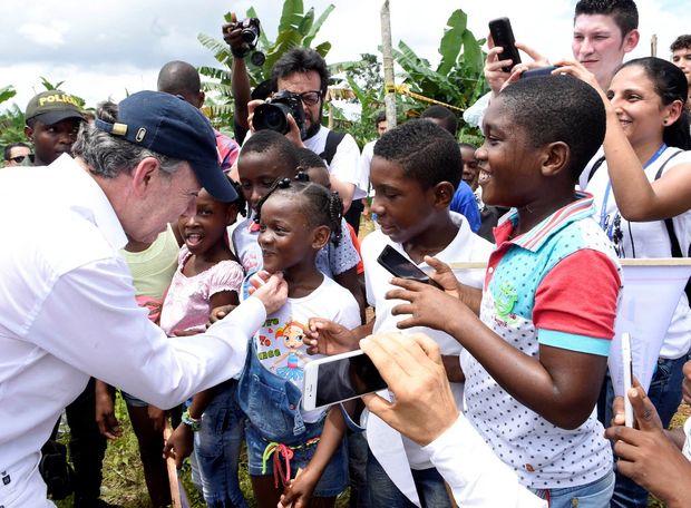 O presidente colombiano Juan Manuel Santos cumprimenta crianas em Bojaya, cidade afetada pela guerra contra as Farc