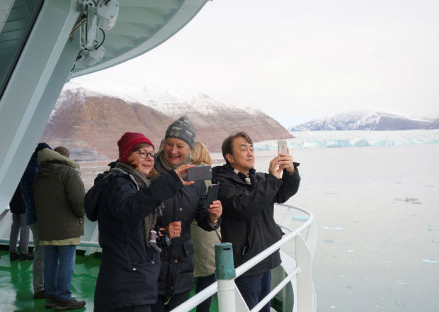 Visitors take pictures of a glacier in the Kongsfjorden fjord from onboard the Polarsyssel, the ship of the Governor of Svalbard, in the Arctic archipelago of Svalbard, Norway, September 20, 2016. Picture taken September 20, 2016. REUTERS/Gwladys Fouche ORG XMIT: INK104
