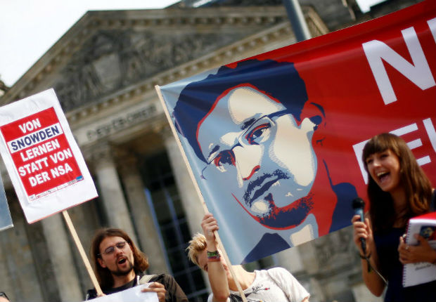 Activists protest with a banner showing the picture of Edward Snowden in front of the Reichstag building, the seat of the lower house of parliament Bundestag, against a planned law reform to Federal Intelligence Service in Berlin, Germany September 26, 2016. The banner reads "Learning from Snowden instead of the NSA."