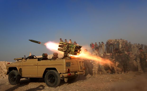 Combatentes curdos lanam mssilde um vilarejo perto da cidade de Bashiqa, durante operao contra o EI