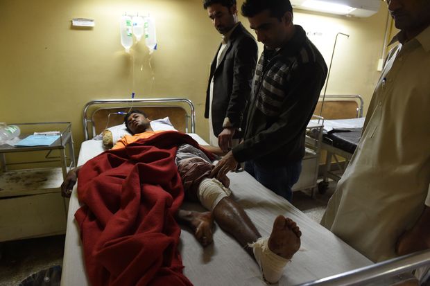 Pakistani men take care of an injured relative at a hospital in Quetta on October 25, 2016, after an overnight militant attack on the Police Training College Balochistan. The death toll from an overnight attack on a police academy in southwest Pakistan has risen to 58 people with dozens more wounded, officials said, in one of the deadliest extremist attacks this year. 