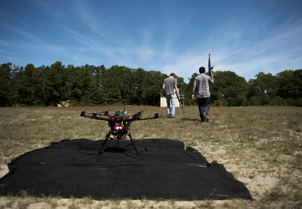 Jacob Regenstein and Ben Krosner with fake rifles for an autonomous drone tracking test at Joint Base Cape Cod, Mass., Aug. 25, 2016. The U.S. has put artificial intelligence at the center of its defense strategy, with weapons that can identify targets and make decisions. (Hilary Swift/The New York Times) 