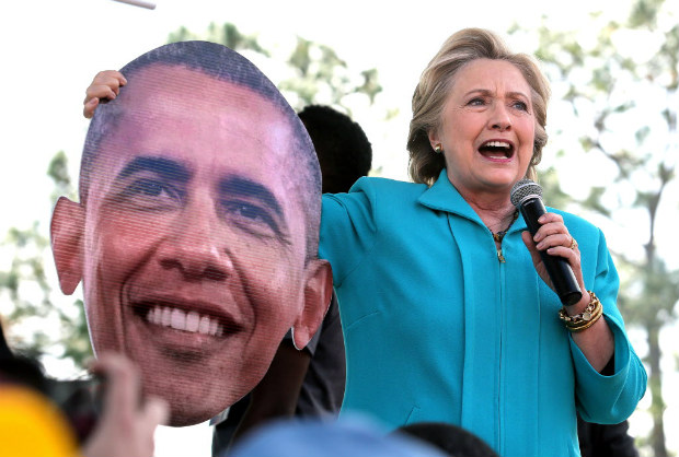  Democratic presidential candidate Hillary Clinton jokes with a giant image of President Barack Obama that was handed to her by a supporter while she delivered remarks to fans at the Bethune-Cookman University homecoming football game, in Daytona Beach, Fla., Saturday, Oct. 29, 2016. (Joe Burbank/Orlando Sentinel via AP) ORG XMIT: FLORL204