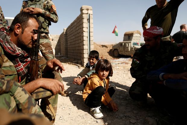 Soldados curdos conversam com crianas que fugiram da vila de Abu Jarbuah, a leste de Mossul