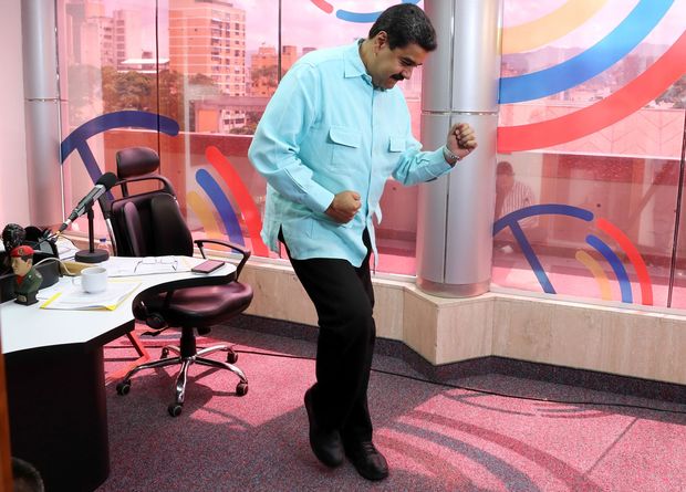  TOPSHOT - Photo released by the Venezuelan Presidency of Venezuelan President Nicolas Maduro dancing during a radio program in Caracas on November 1, 2016. Opposition lawmakers suspended a 