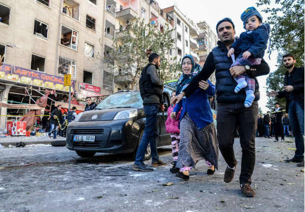 People run the streets near the explosion site on November 4, 2016 after a strong blast in the southeastern Turkish city of Diyarbakir. Eight people were killed, including two police, and over 100 wounded in a car bombing by Kurdish militants in the southeastern Turkish city of Diyarbakir, Prime Minister Binali Yildirim said on November 4, 2016, updating an earlier toll. The blast, which Yildirim said was carried out by the outlawed Kurdistan Workers Party (PKK), targeted a police headquarters hours after top Kurdish politicians were detained in an unprecedented police crackdown. / AFP PHOTO / ILYAS AKENGIN ORG XMIT: 9256
