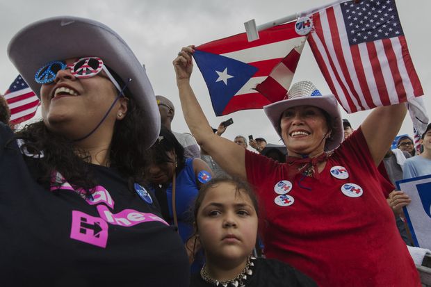 PEMBROKE PINE, FLORIDA. 05-11-2016. A porto-riquenha Amparo Gomez segura as bandeiras de Porto Rico e dos Estados Unidos durante comcio da candidata democrata Hillary Clinton a presidncia dos Estados Unidos, em Pembroke Pines na Florida. A esquerda de culos sua filha, a advogada Lisette Dede.
