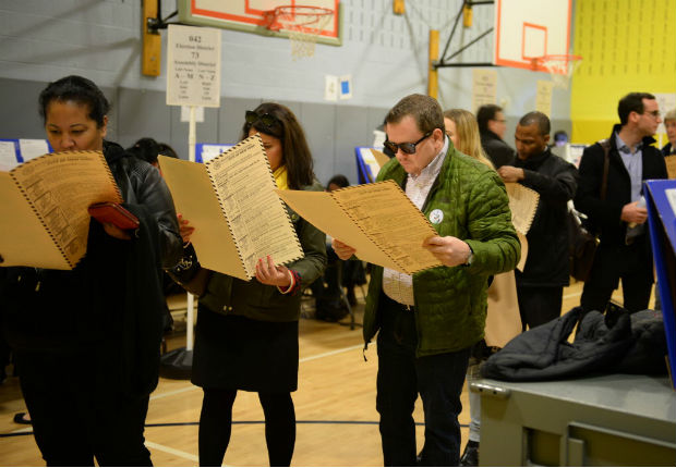 Eleitores leem cédulas antes de votar em ginásio em Nova York