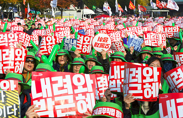 Tens of thousands of protesters hold up signs calling for the resignation of South Korean President Park Geun-Hye during an anti-government rally following presidential scandal in central Seoul on November 12, 2016. Tens of thousands of men, women and children joined one of the largest anti-government protests seen in Seoul for decades on November 12, demanding President Park Geun-Hye's resignation over a snowballing corruption scandal. / AFP PHOTO / JUNG YEON-JE ORG XMIT: JYJ501