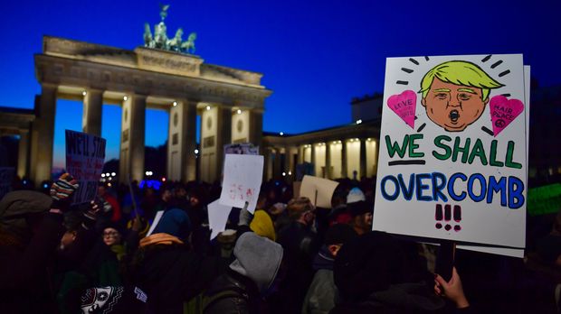  A demonstrator protesting against US president-elect Donald Trump displays a placard featuring a likeness of Trump during a demonstration at Berlin's Brandenburg Gate on November 12, 2016. / AFP PHOTO / John MACDOUGALL