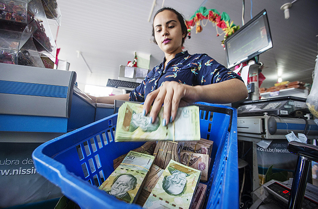 A caixa de supermercado Iara Siqueira, 21, mostra cesta com 200 mil bolvares (R$ 330) em Pacaraima