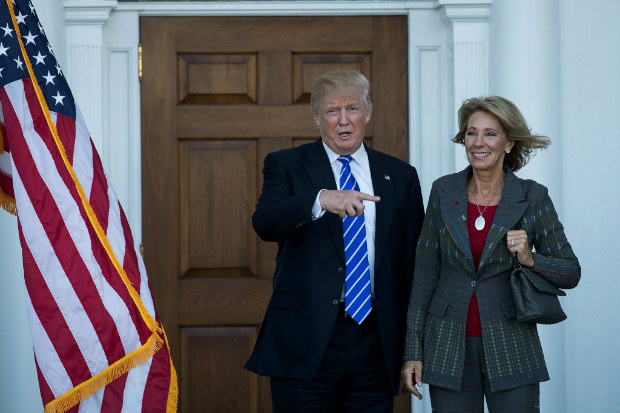 (FILES) This file photo taken on November 18, 2016 shows president-elect Donald Trump and Betsy DeVos after their meeting at Trump International Golf Club, in Bedminster Township, New Jersey. US President-elect Donald Trump announced November 23, 2016 that he intends to nominate Betsy DeVos, a wealthy Republican campaigner for alternatives to public schools, as his education secretary.DeVos is the second woman Trump has tapped to fill a cabinet position. He earlier named South Carolina Governor Nikki Haley to be US ambassador to the United Nations. / AFP PHOTO / GETTY IMAGES NORTH AMERICA / Drew Angerer