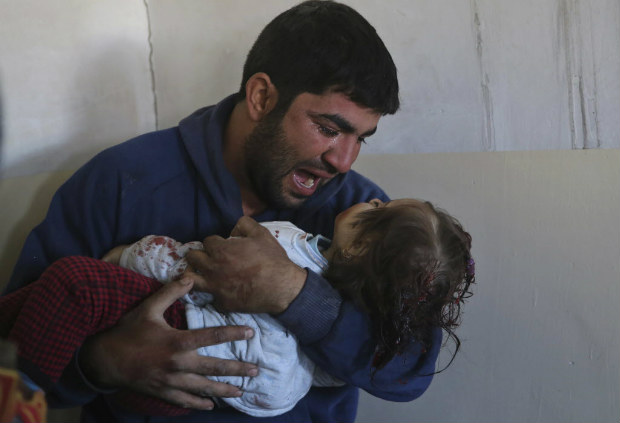 Homem segura a filha Amira, de 1 ano, morta por morteiro em Mossul