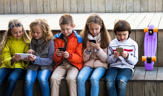 Crianças usando celulares e tablets