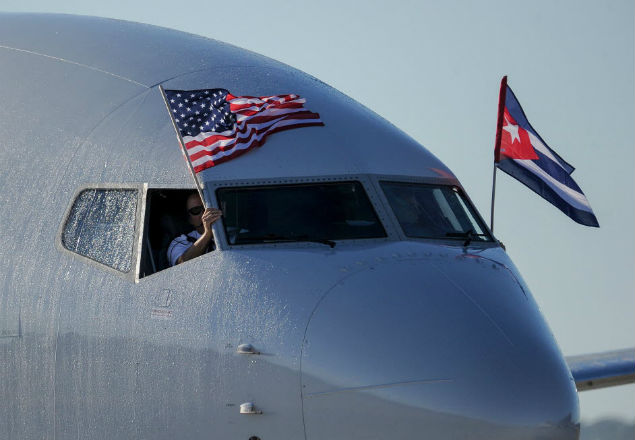 TOPSHOT - An American Airlines plane fluttering US and Cuba national flags is seen uppon arrival at Jose Marti International Airport becoming the first Miami-Havana commercial flight in 50 years, coinciding with the beginning of the tributes to late Cuban leader Fidel Castro, on November 28, 2016 in Havana. / AFP PHOTO / YAMIL LAGE ORG XMIT: HAV08