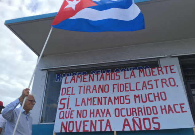 O advogado cubano Zenen Perez Yera diante do cartaz que preparou para a festa pela morte de Fidel em Little Havana, Miami na festa da oposicao cubana em Miami, alegria com a morte de Fidel gera dilemas morais.