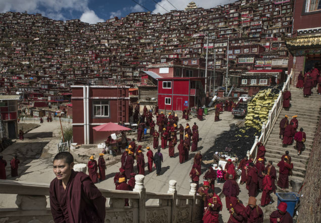 Monks in gather in Larung Gar, China, Oct. 8, 2016. In Larung Gar, the world’s largest Buddhist institute, demolition teams are cutting through an extraordinary vista of hand-built red dwellings. (Gilles Sabrie/The New York Times) 