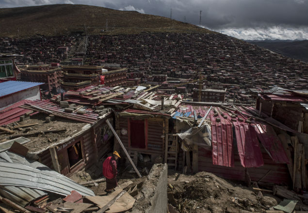 Buddhist nuns go through the ruins of dismantled homes in Larung Gar, China, Oct. 8, 2016. China says the settlement is overcrowded and unsafe, but Tibetans claim the government’s aim is to weaken centers of power that can rival it. (Gilles Sabrie/The New York Times)