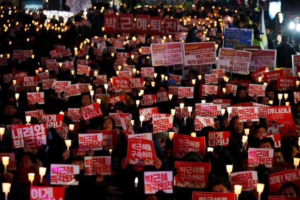 People chant slogans during a protest calling for South Korean President Park Geun-hye to step down in central Seoul, South Korea, November 29, 2016. The sign reads "Step down Park Geun-hye immediately". REUTERS/Kim Hong-Ji