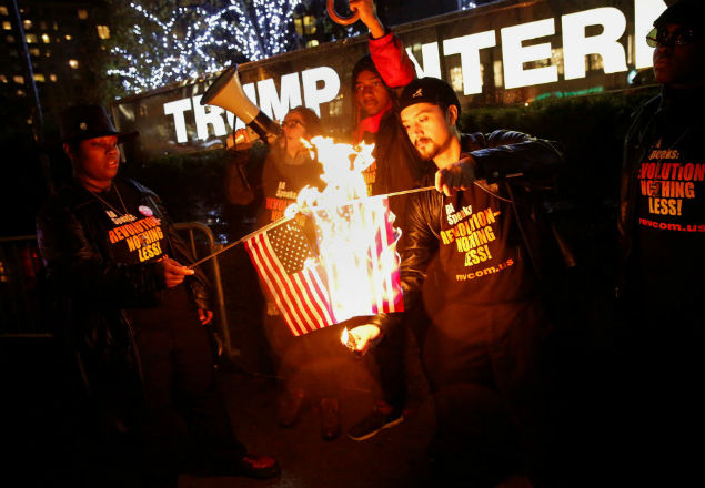 Supporters of the "NYC Revolution Club" burn the U.S. flag outside the Trump International Hotel and Tower in New York, U.S., November 29, 2016. REUTERS/Shannon Stapleton ORG XMIT: SHN108