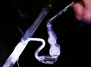Usurio de metanfetamina fuma a droga em cachimbo de vidro