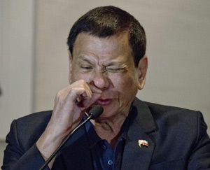 Philippine President Rodrigo Duterte demonstrates how a drug addict sniffs drugs during a press conference in Beijing, China, Wednesday, Oct. 19, 2016. Duterte's effusive message of friendship on his visit to Beijing this week has handed China a public relations bonanza just three months after Beijing suffered a humiliating defeat by an international tribunal. 