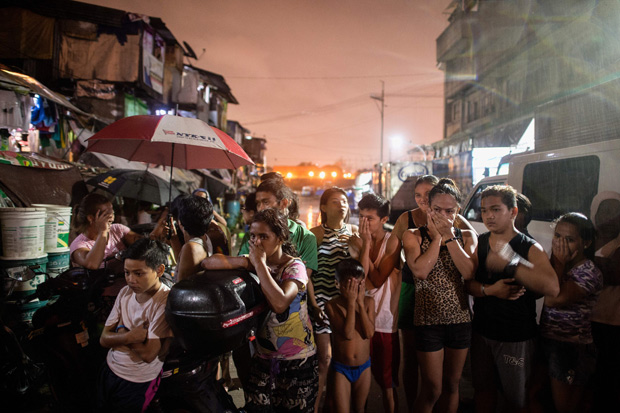 In this picture taken on September 28, 2016, residents react near a crime scene where three alleged drug dealer were killed after a drug raid in a shanty community in Manila. Philippine President Rodrigo Duterte defended his threat to kill criminals as 