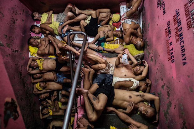  In this photo taken on July 21, 2016 inmates sleep on the steps of a ladder inside the Quezon City jail at night in Manila. There are 3,800 inmates at the jail, which was built six decades ago to house 800, and they engage in a relentless contest for space. Men take turns to sleep on the cracked cement floor of an open-air basketball court, the steps of staircases, underneath beds and hammocks made out of old blankets