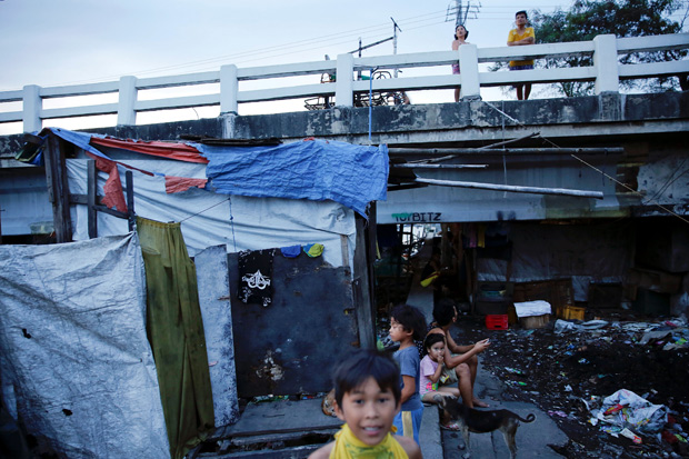 People pass the time under C-3 bridge in North Bay Boulevard South (NBBS), a Navotas City district of slums and waterways with a high number of drug war deaths, in Manila, Philippines November 3, 2016.
