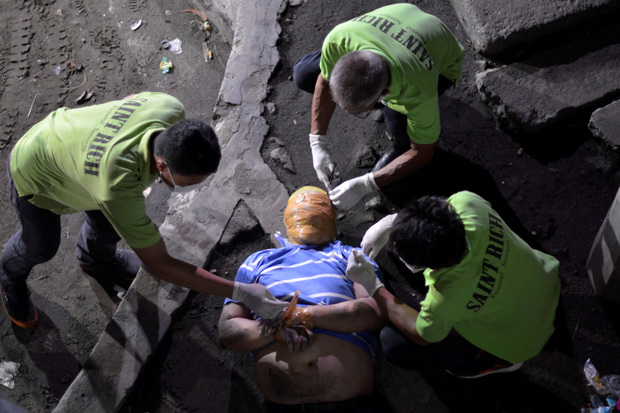 COVERAGE OF SCENES OF INJURY OR DEATH Funeral workers remove the masking tape wrapped around the head and the wrists of the body of a man, who police said is a victim of drug related vigilante execution in Manila, Philippines September 21, 2016.